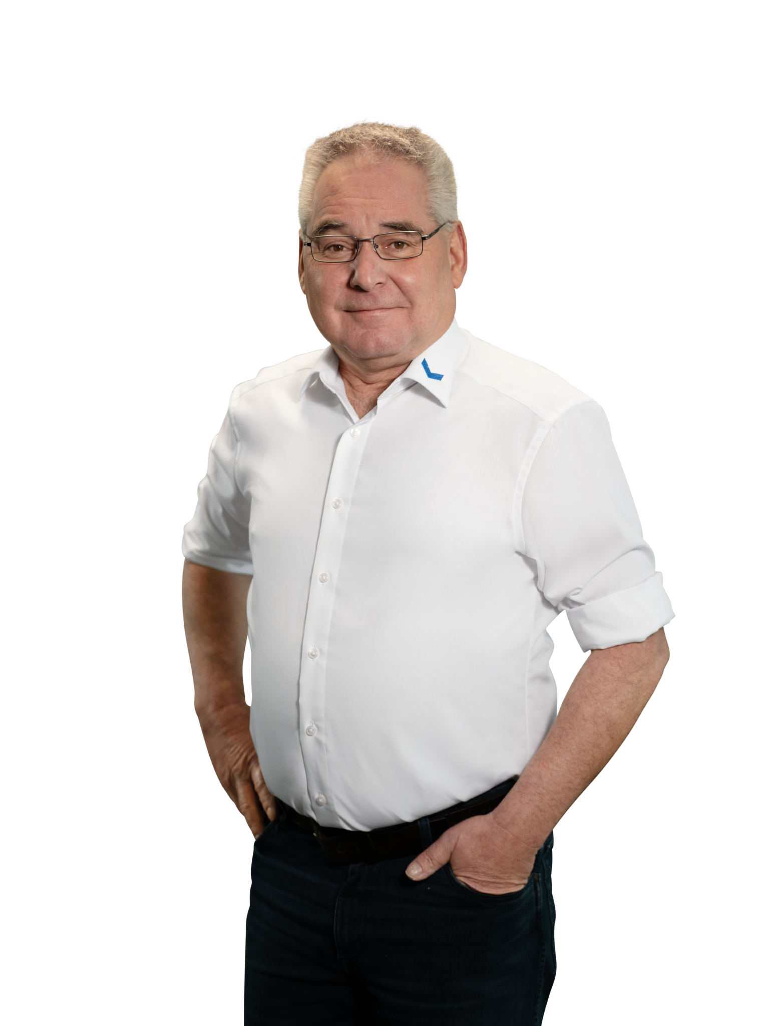 Älterer Mann in weißem Hemd mit Brille und verschränkten Armen.