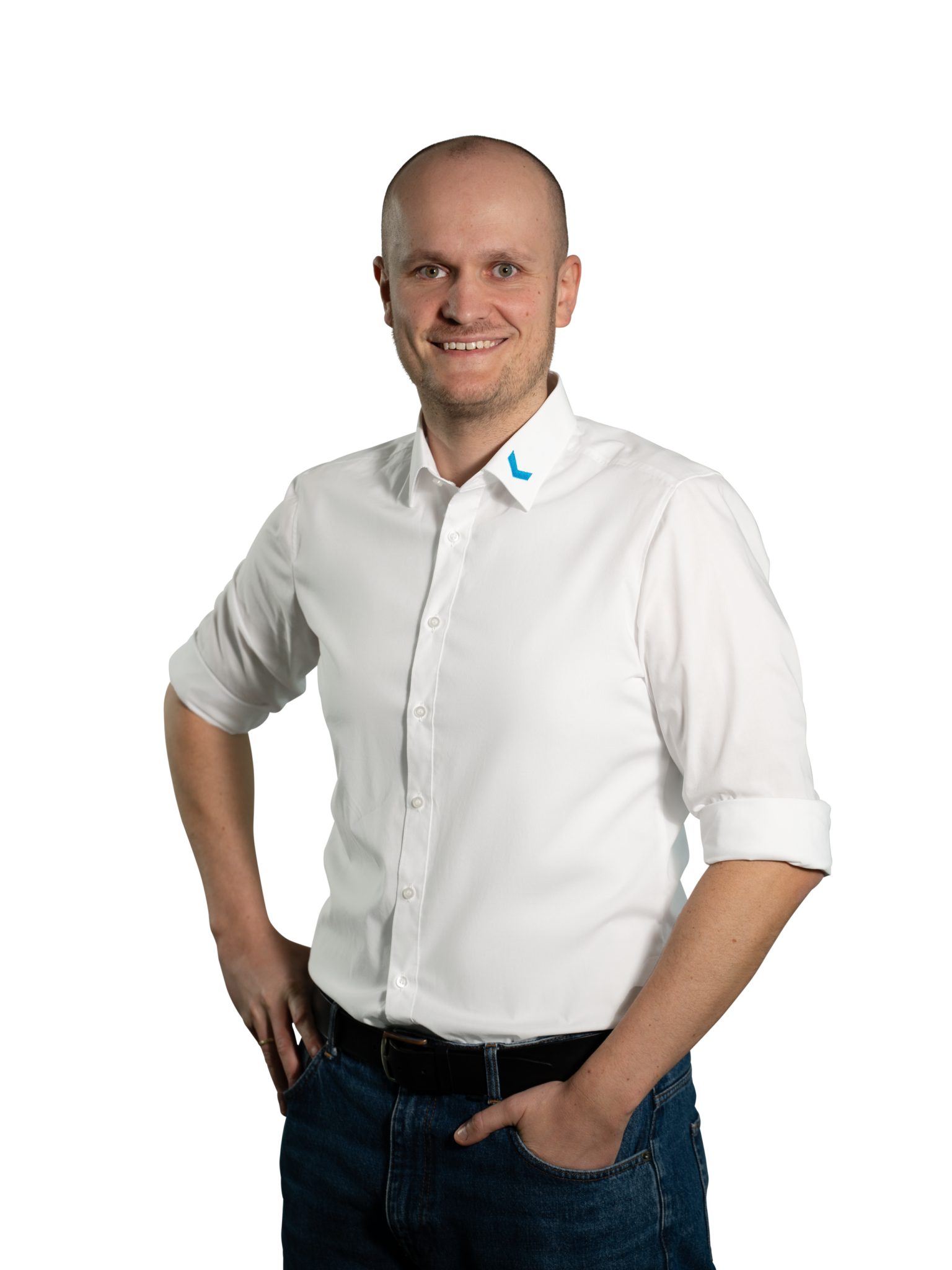 Mann in weißem Hemd mit aufgerollten Ärmeln und blauer Jeans.