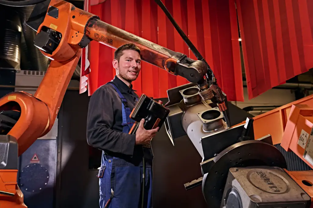 Mechanical Fabrication Technician working on a welding robot at the contract manufacturer SPALECK
